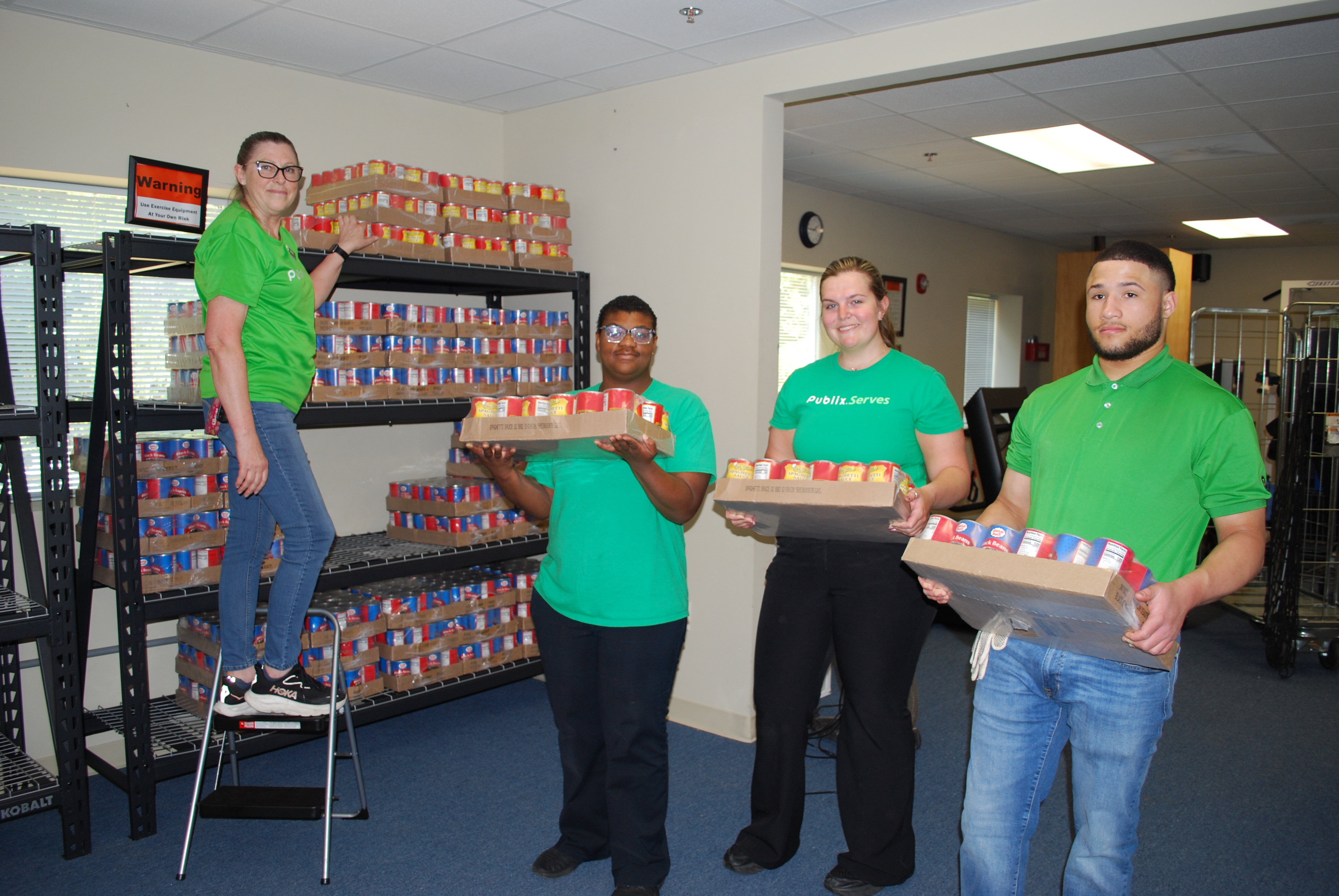 Publix employees are shown volunteering to stack food at Agape in Bluffton.