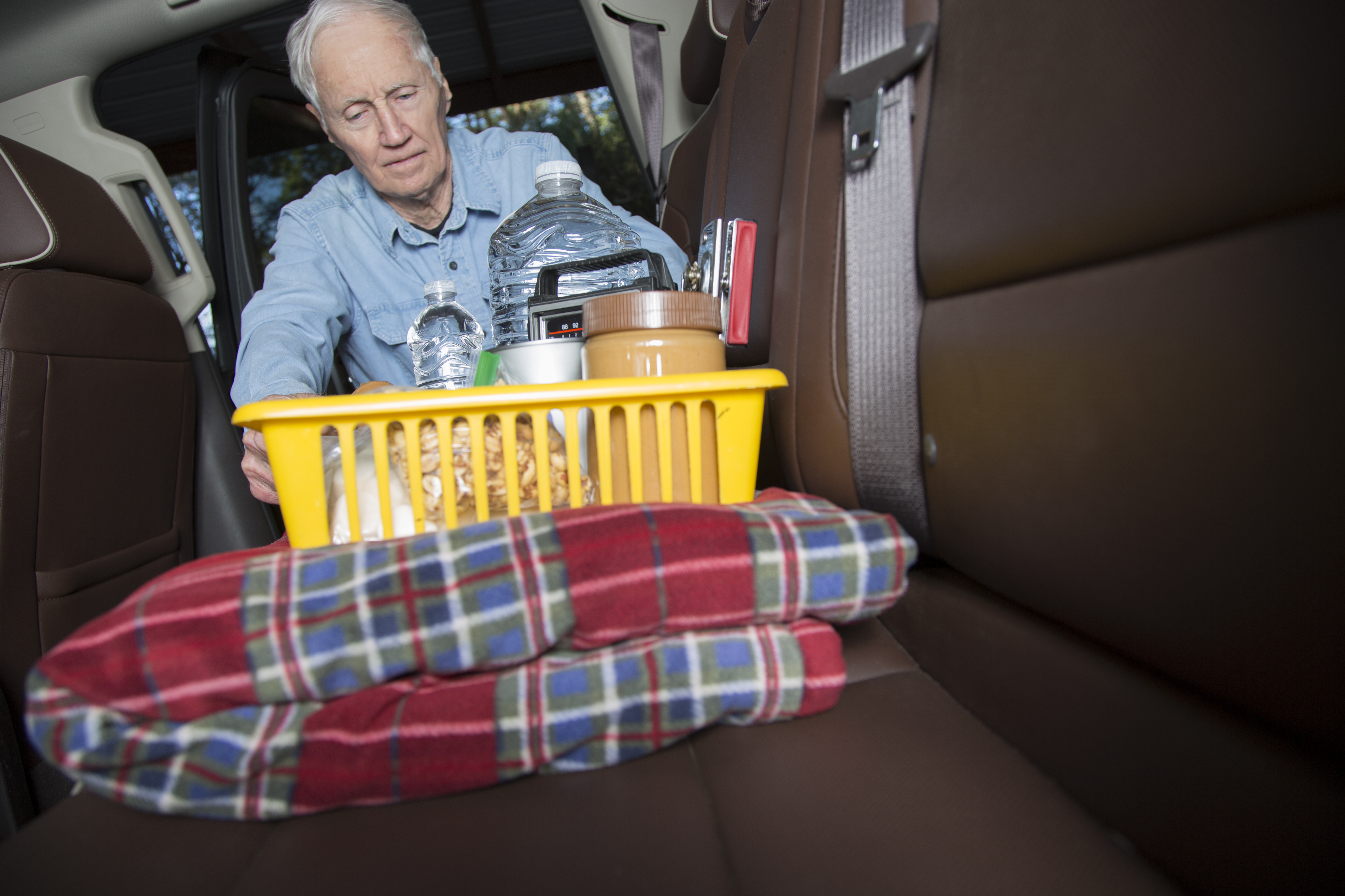 older man with supplies in a laundry basket