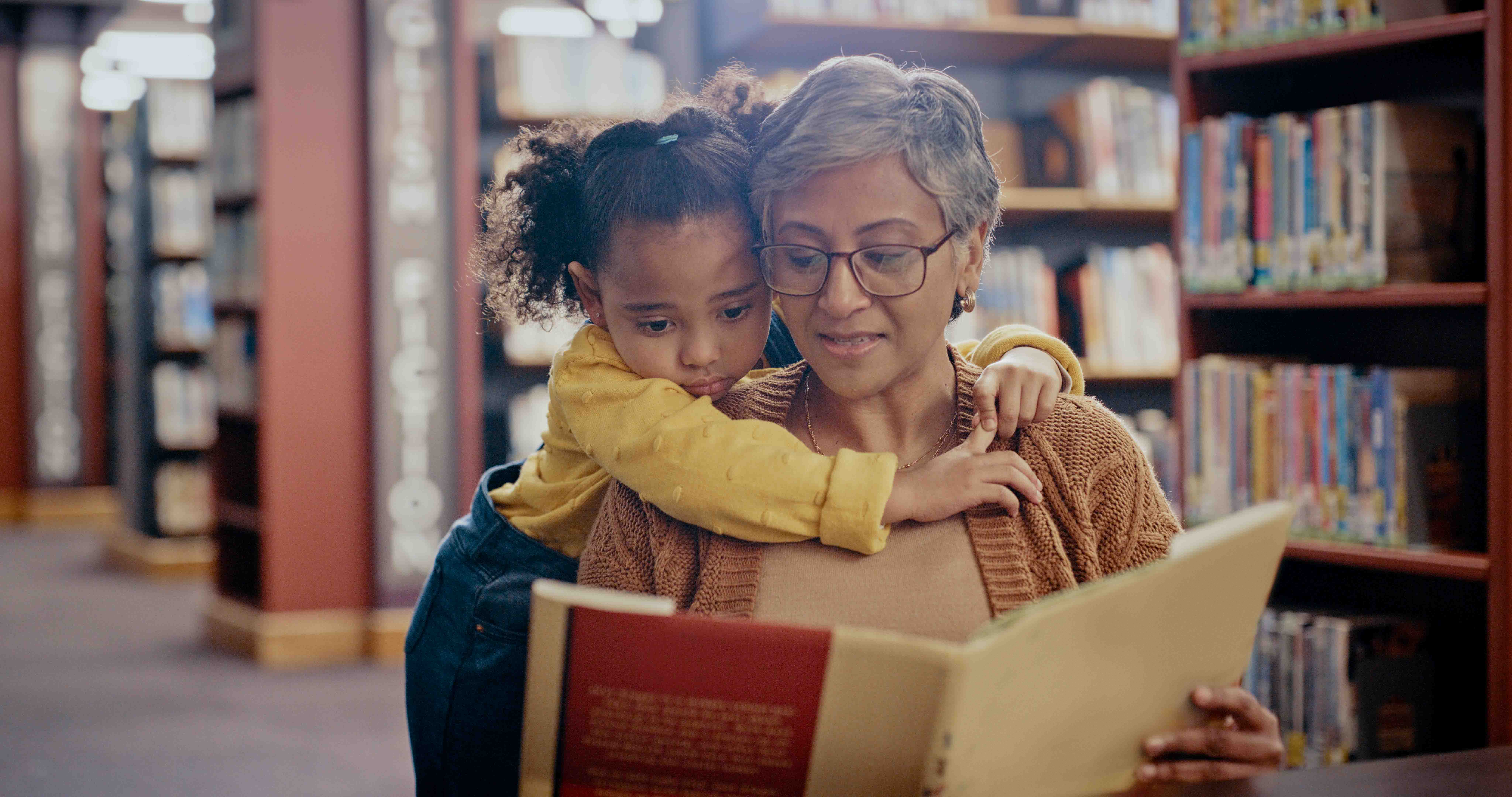 woman reading to a young girl in a library