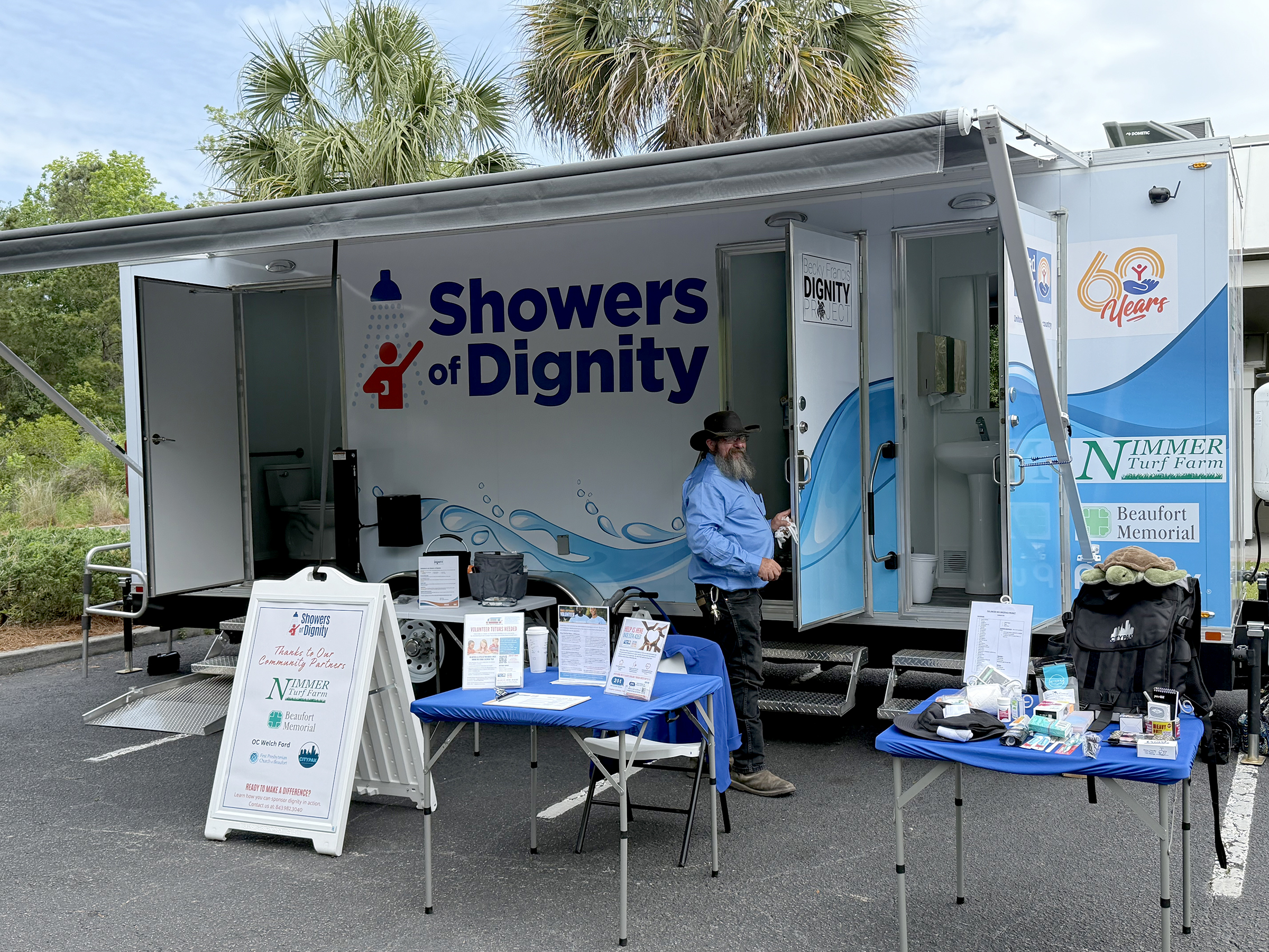 showers of dignity trailer with the driver pictured in front of the door